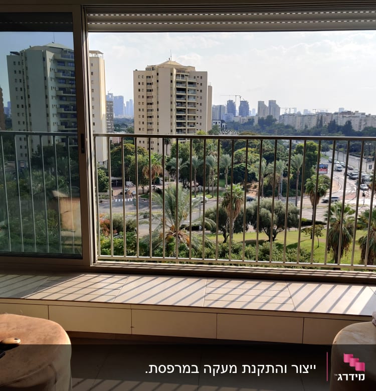 חלון גדול עם מסגרת מתכת ונוף עירוני